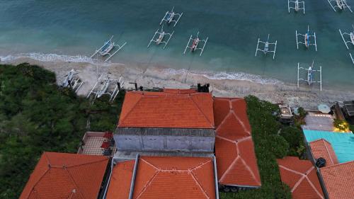 an aerial view of a beach with red roofs at Barton Beach Inn in Nusa Penida