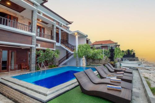 a villa with a swimming pool and a house at Barton Beach Inn in Nusa Penida