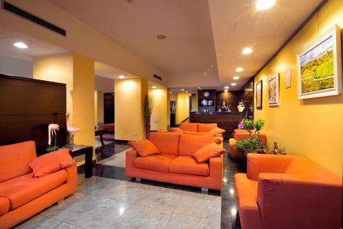 a waiting room with orange couches in a lobby at Hotel Il Viandante in Terranuova Bracciolini