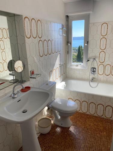 une salle de bain avec un lavabo, des toilettes et une baignoire dans l'établissement Villa du Parc, à Cavalaire-sur-Mer