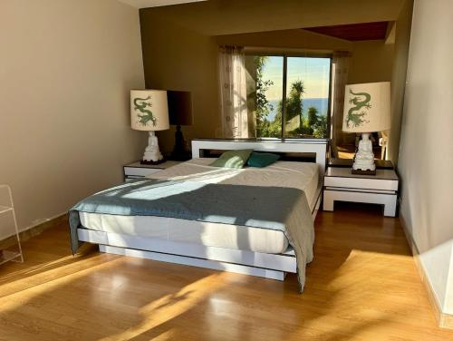 une chambre avec un lit et deux tables de nuit avec lampes dans l'établissement Villa du Parc, à Cavalaire-sur-Mer