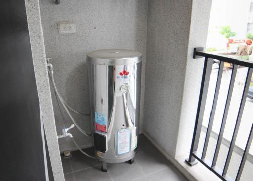 a water heater in the corner of a room at 愛麗徠綜合文旅會館 in Tainan