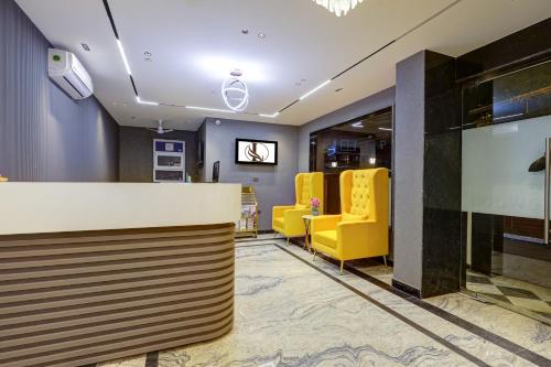 a lobby with yellow chairs and a reception desk at Limewood Stay Premium Studios - Near Sector 29 in Gurgaon