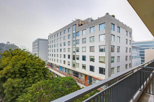 a white building in the middle of a city at Limewood Stay Premium Studios - Near Sector 29 in Gurgaon