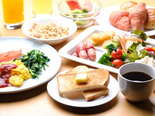 een tafel met borden met ontbijtproducten en drankjes bij Hotel Abest Happo Aldea in Hakuba