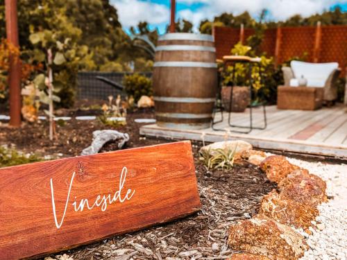 a sign that says vaughnia sitting in a garden at Welcome to Vineside in Witchcliffe