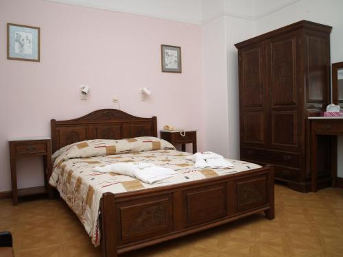 a bedroom with a large bed with wooden furniture at Acropolis House in Athens