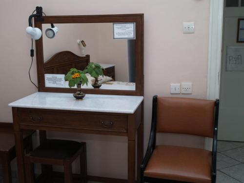 a dresser with a mirror and a plant on it at Acropolis House in Athens