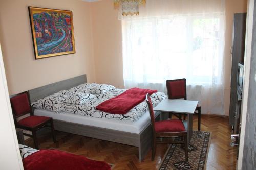 um quarto com uma cama, 2 cadeiras e uma mesa em Diófa Vendégház em Bükkszék