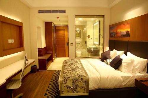 a bedroom with a large bed and a bathroom at The P L Palace Agra in Agra