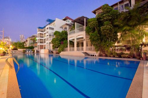 a large blue swimming pool in front of some buildings at Argyle Apartments Pattaya in Pattaya South