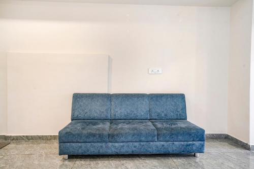 a blue couch in a room with a wall at FabHotel SR Naroda - Nr Akshardham in Ahmedabad