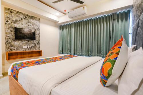 a bedroom with a large bed and a window at FabHotel SR Naroda - Nr Akshardham in Ahmedabad