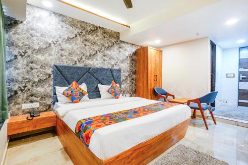 a bedroom with a bed and a table and chairs at FabHotel SR Naroda - Nr Akshardham in Ahmedabad