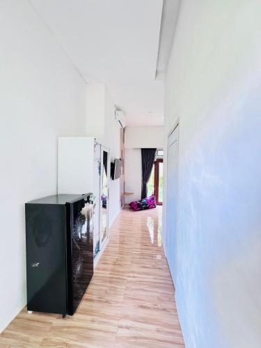 a hallway with white walls and a wooden floor at The Inside House Medewi in Airsatang