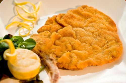 a plate of food with a piece of fish and a lemon at Villa Noce in Brescia