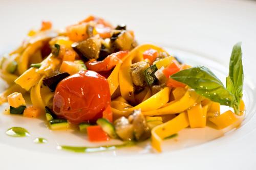 a plate of food with vegetables on a white plate at Villa Noce in Brescia