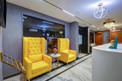 a lobby with two yellow chairs and a table at Limewood Stay Premium Studios - Near Sector 29 in Gurgaon