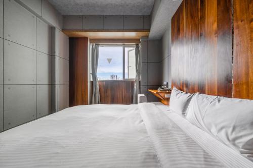 a bedroom with a large bed and a window at CHECK inn Express Taichung Fengchia in Taichung