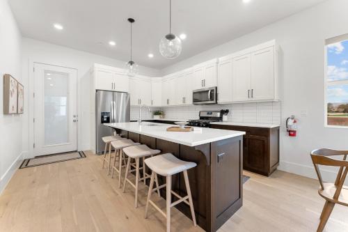 a kitchen with white cabinets and a large island with bar stools at Villa #33 at Bloomington Country Club condo in St. George