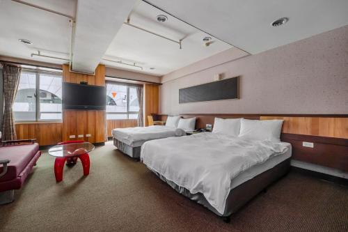 a hotel room with two beds and a couch at CHECK inn Express Taichung Fengchia in Taichung