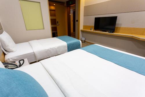 a hospital room with two beds and a flat screen tv at The Recenz Dongdaemun Hotel in Seoul