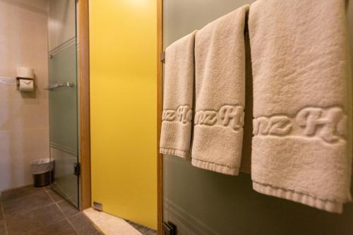 a bathroom with towels hanging on a door at The Recenz Dongdaemun Hotel in Seoul