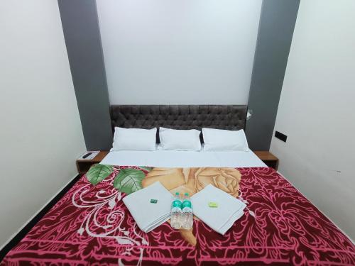 a bed with two envelopes on top of it at Hotel Shreem in Ujjain