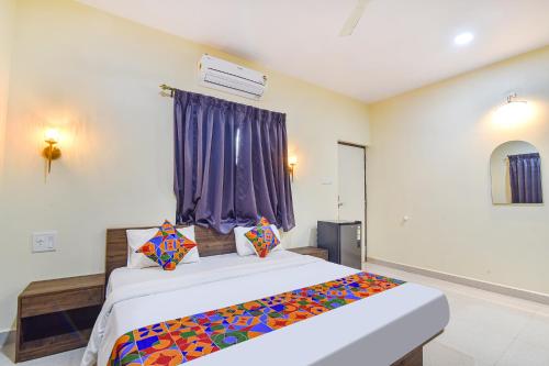 a bedroom with a bed with a colorful blanket on it at Fabhotel Baga Tulip - 500M From Baga Beach in Baga