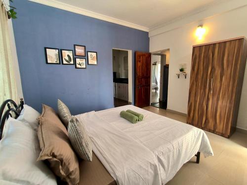 a bedroom with a large bed with a blue wall at Villa NAMAKA in Morjim