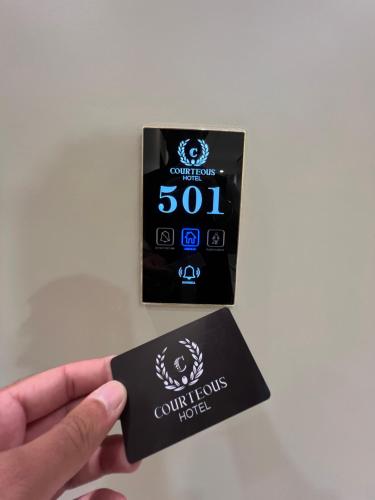 a person holding a credit card in their hand at Courteous Hotel in Islamabad