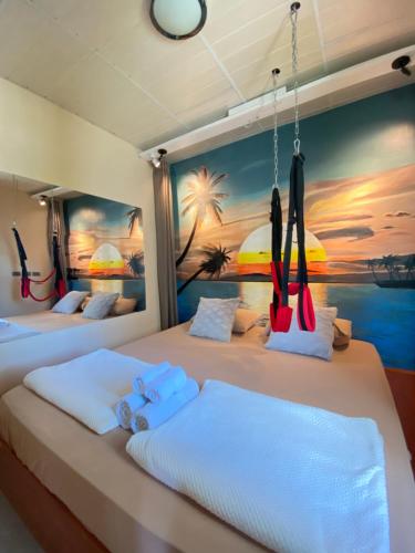 two beds in a room with a painting on the wall at Moalboal LRS Lovers Nest in Basdiot