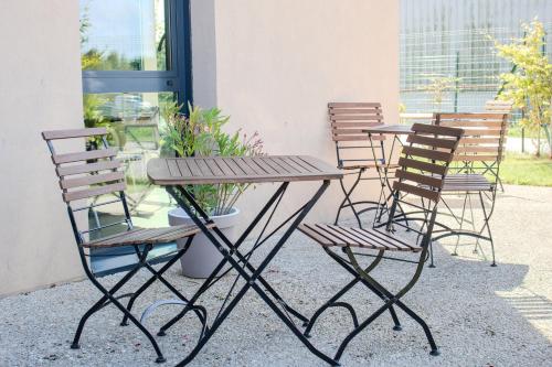a table and chairs sitting next to a building at Brit Hotel Dieppe in Dieppe