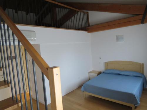 a small bedroom with a bed and a staircase at Tenuta Monterosso in Feriole