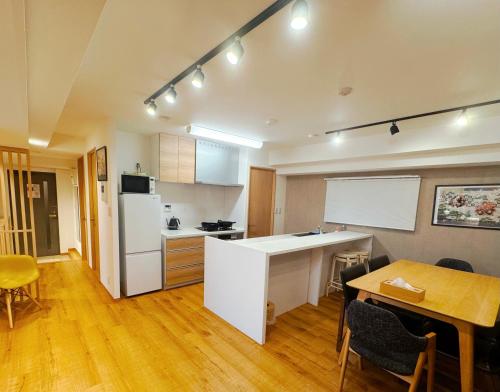 a kitchen with a table and a white refrigerator at 浅草スカイツリービューテラス 浅草寺3分 浅草駅6分 2-10人 成田&羽田空港直通 in Tokyo
