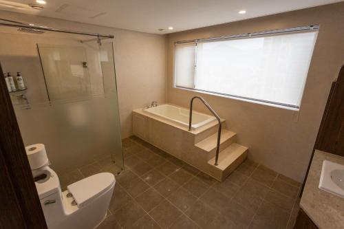 a bathroom with a toilet and a tub and a sink at The Recenz Dongdaemun Hotel in Seoul
