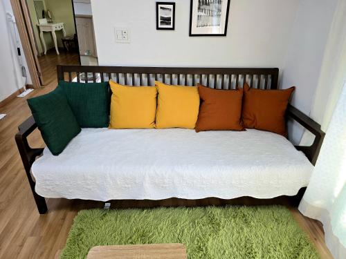 a couch with colorful pillows on it in a room at Detached house with a large yard, 15 minutes from the sea in Hwaseong in Hwaseong
