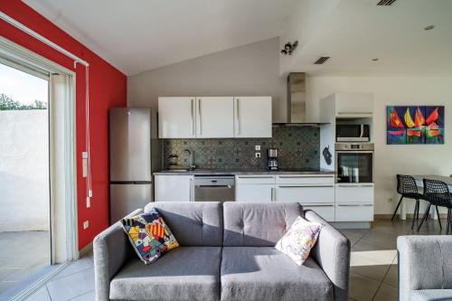 un salon avec un canapé et une cuisine dans l'établissement La maison près de la mer, à Latour-Bas-Elne