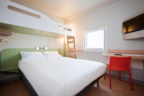 a bedroom with a large bed and a red chair at ibis budget Saint-Omer Centre in Saint-Omer