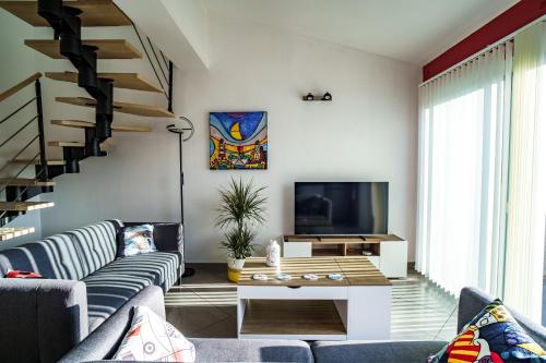 un salon avec un canapé et une télévision dans l'établissement La maison près de la mer, à Latour-Bas-Elne