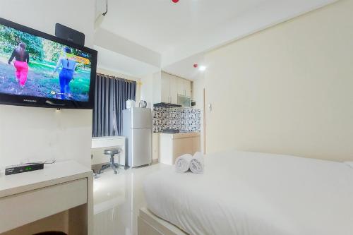 タンゲランにあるGood Choice and Comfy Studio Apartment B Residence By Travelioのベッド1台、薄型テレビが備わる客室です。