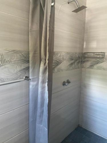 a shower with a shower curtain in a bathroom at Bennyz Guest House in Pretoria