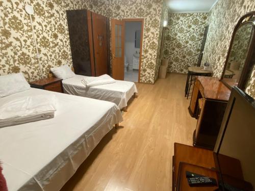a hotel room with two beds and a television at 4 Seasons in Boryspilʼ