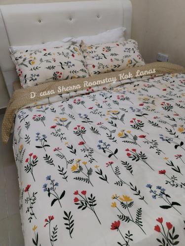 KeterehD'casa Sherra Homestay Kok Lanas的一张带白色棉被和鲜花的床