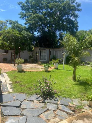 a house with a garden with a stone walkway at Bennyz Guest House in Pretoria