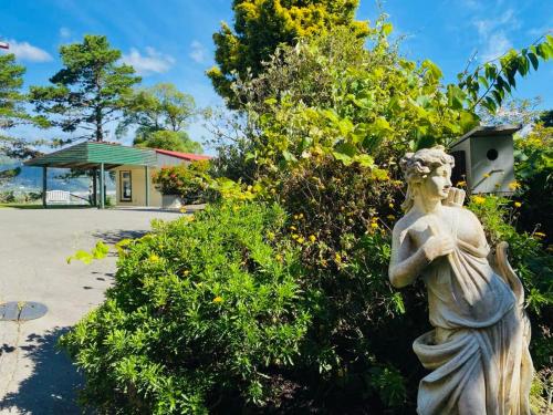 a statue of a woman standing in front of a bush at NEW Miromiro Serenity, entire guest house, central in Lower Hutt