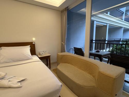 a hotel room with a bed and a balcony at Green Garden Hotel in Kuta