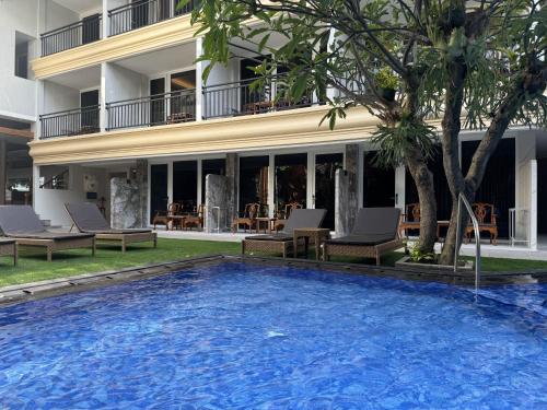 a swimming pool in front of a hotel at Green Garden Hotel in Kuta