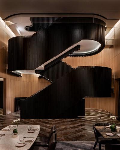 a restaurant with a black wall and tables and chairs at Park Hyatt Toronto in Toronto