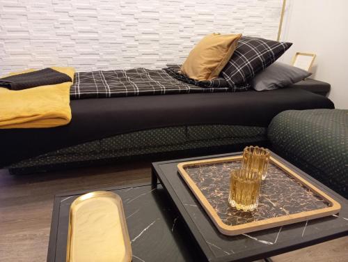 a black couch with a tray on a table at Black Diamond Lux - deluxe riverside apartment in Senta